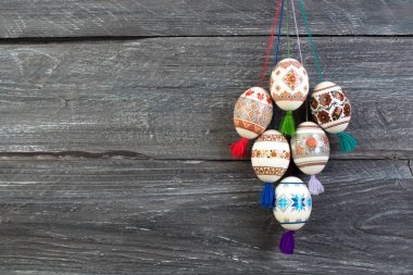 Mutlu paskalya kartı. Gri ahşap masa arka plan üzerinde renkli parlak Paskalya yumurtaları. Metin için yer kopyalayın