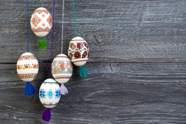 Mutlu paskalya kartı. Gri ahşap masa arka plan üzerinde renkli parlak Paskalya yumurtaları. Metin için yer kopyalayın