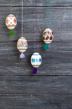 Mutlu paskalya kartı. Gri ahşap masa arka plan üzerinde renkli parlak Paskalya yumurtaları. Metin için yer kopyalayın