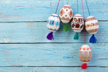 Mutlu paskalya kartı. Mavi ahşap masa arka plan üzerinde renkli parlak Paskalya yumurtaları. Metin için yer kopyalayın