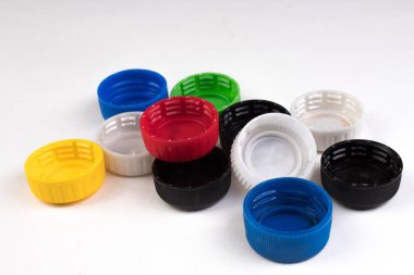 Beyaz arka plan üzerinde izole farklı renkteki birçok plastik kapakları. Plastik geri dönüşüm kavramı.