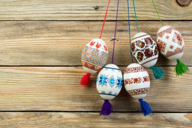 Mutlu paskalya kartı. Ahşap masa arka plan üzerinde renkli parlak Paskalya yumurtaları. Metin için yer kopyalayın