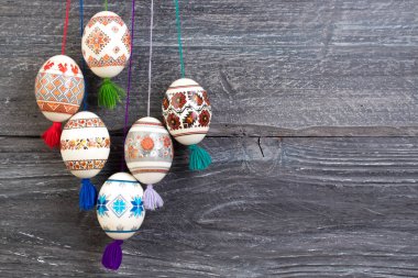 Mutlu paskalya kartı. Gri ahşap masa arka plan üzerinde renkli parlak Paskalya yumurtaları. Metin için yer kopyalayın