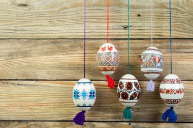 Mutlu paskalya kartı. Ahşap masa arka plan üzerinde renkli parlak Paskalya yumurtaları. Metin için yer kopyalayın