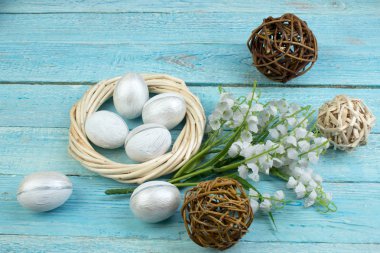 Mutlu Paskalyalar. Tahta arka planda yumurtalar... Toplar, sarmaşıklardan örülmüş çelenkler. Uzayı metin için kopyala. Üst görünüm