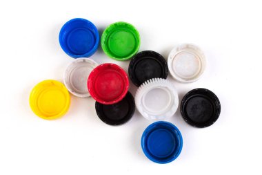 Beyaz arka plan üzerinde izole farklı renkteki birçok plastik kapakları. Plastik geri dönüşüm kavramı.