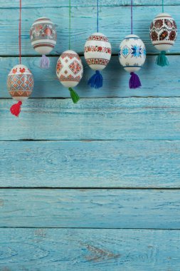 Mutlu paskalya kartı. Mavi ahşap masa arka plan üzerinde renkli parlak Paskalya yumurtaları. Metin için yer kopyalayın