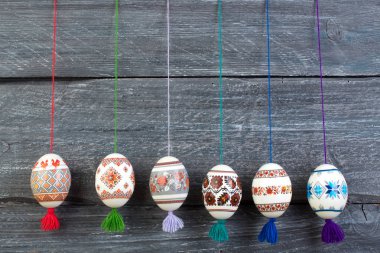 Mutlu paskalya kartı. Gri ahşap masa arka plan üzerinde renkli parlak Paskalya yumurtaları. Metin için yer kopyalayın