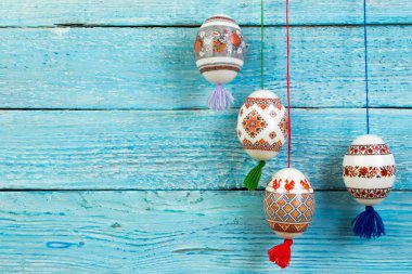 Mutlu paskalya kartı. Mavi ahşap masa arka plan üzerinde renkli parlak Paskalya yumurtaları. Metin için yer kopyalayın