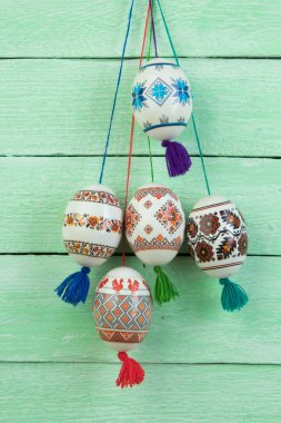 Mutlu paskalya kartı. Yeşil ahşap masa arka plan üzerinde renkli parlak Paskalya yumurtaları. Metin için yer kopyalayın