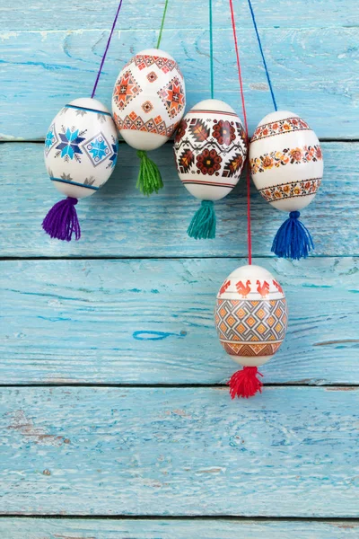Mutlu paskalya kartı. Mavi ahşap masa arka plan üzerinde renkli parlak Paskalya yumurtaları. Metin için yer kopyalayın
