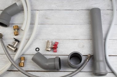 Teçhizatlar, boru, valfler, su için plastik boru ahşap arka planda ayarlanabilir ingiliz anahtarı. Üst Manzara. Metin için alanı kopyala