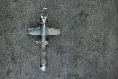 Gri beton duvarda musluk var. Uzayı kopyala Üst görünüm