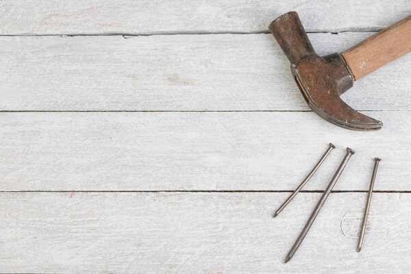 Молоток когтей, гвозди изолированы на деревянном фоне. Вид сверху

