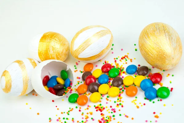 Happy Easter. Broken Easter egg with multi-colored candy decorations. on white background. Colorful eggs