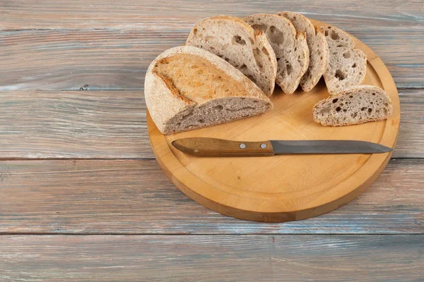 Many mixed breads and rolls of baked bread on wooden table background