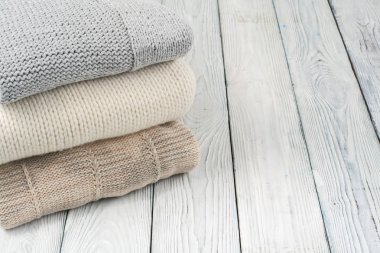 Örgü yün kazaklar. Ahşap arka planda örülmüş kış kıyafetleri, kazaklar, örgü giysileri, metin için yer.