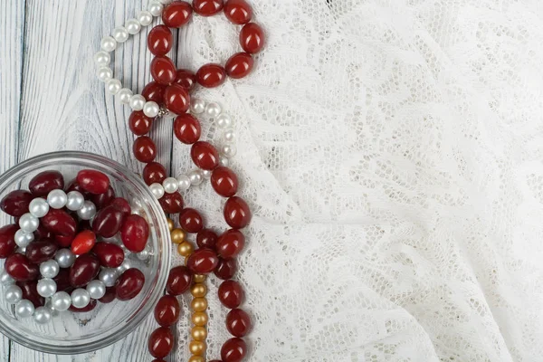 Making of handmade jewellery. Box with beads, spool of threads, needle on wooden background. Handmade accessories