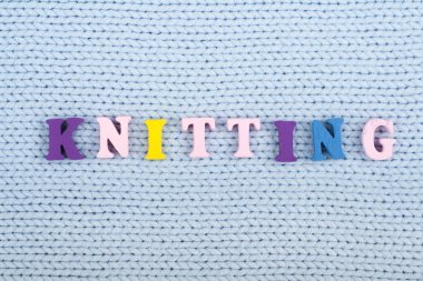 Örgü. Mavi örme kumaş dokusu. ABC alfabesi harfleri oluşan kelime