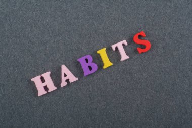 Alışkanlıkları kelime kara tahta arka plan üzerinde renkli abc alfabe blok ahşap harfler, reklam metni için kopya alanı üzerinden oluşur. Öğrenme İngilizce kavramı