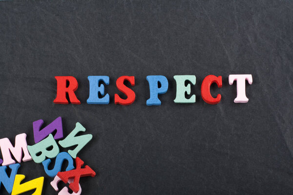 RESPECT word on black board background composed from colorful abc alphabet block wooden letters, copy space for ad text. Learning english concept