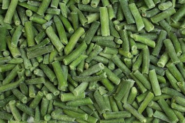 kıyılmış kuşkonmaz fasulye donmuş. Üstten Görünüm. yeşil arka plan balmumu fasulye