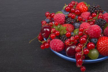 Bir kase rustik ahşap masa üzerinde çeşitli yaz taze çilek. Antioksidan, detoks diyet, organik meyve