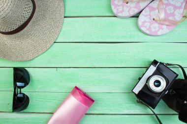 Şapka, kamera, çanta, gözlük, yaz için ahşap arka planda güneş kremi. Üst görünüm ve kopyalama alanı