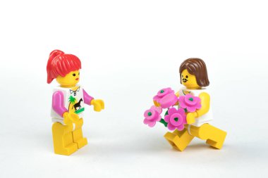 Kukla figürler Lego beyaz arka plan üzerinde. Bir randevu, bir erkek bir kadın çiçek verir.