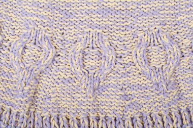 Süveter ya da atkı kumaş dokusu büyük örgü. Örülmüş forma ve kabartma desenli. Örgü ören örgüler. Yün el yapımı makine, el yapımı..