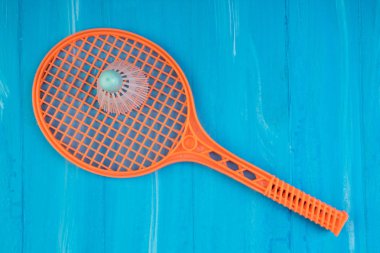 Badminton raketi ve mavi ahşap arka planda mekik siki. Üst görünüm