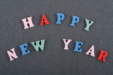 Mutlu yeni yıl kelime kara tahta arka plan üzerinde renkli abc alfabe blok ahşap harfler, reklam metni için kopya alanı üzerinden oluşur. Öğrenme İngilizce kavramı.