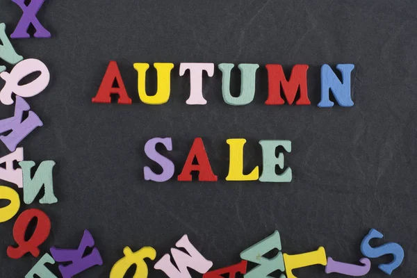 Autumn sale word on black board background composed from colorful abc alphabet block wooden letters, copy space for ad text. Learning english concept. — Stock Photo, Image