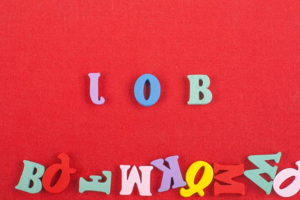 Parola JOB su sfondo rosso composto da lettere colorate alfabeto abc blocco di legno, spazio copia per il testo dell'annuncio. Imparare l'inglese concetto . — Foto Stock