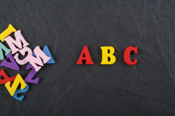 Slovo ABC na černé desce pozadí složená z barevné abc blok dřevěné písmena abecedy, kopie prostor pro reklamní text. Anglický pojem učení. — Stock fotografie