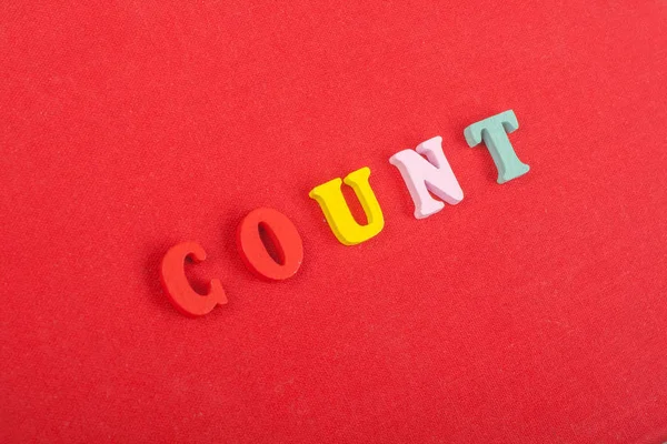 COUNT word on red background composed from colorful abc alphabet block wooden letters, copy space for ad text. Learning english concept.