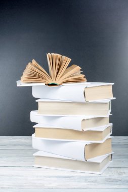 Ahşap masa, siyah tahta arka plan açık kitap. Okula dönüş. Eğitim iş kavramı.