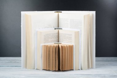 Açık kitap. Ahşap masa, siyah tahta arka plan üzerinde beyaz kitaplar. Okula dönüş. Eğitim iş kavramı.