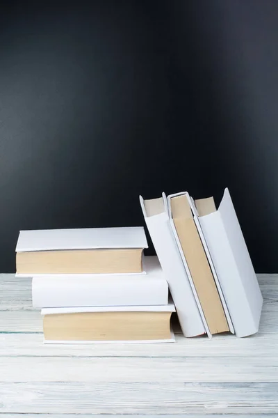 Libros abiertos sobre mesa de madera, fondo de pizarra negra. De vuelta a la escuela. Concepto de negocio educativo . —  Fotos de Stock