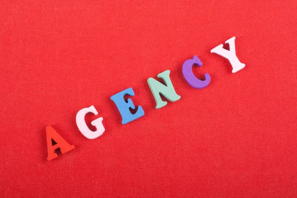 AGENCY word on red background composed from colorful abc alphabet block wooden letters, copy space for ad text. Learning english concept