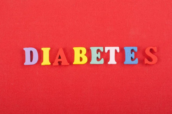 Diabetetes kelime kırmızı arka plan üzerinde renkli abc alfabe blok ahşap harfler, reklam metni için kopya alanı üzerinden oluşur. Öğrenme İngilizce kavramı