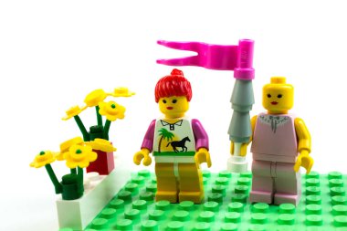 Kukla figürler Lego beyaz arka plan üzerinde. Bir randevu, bir erkek bir kadın çiçek verir.