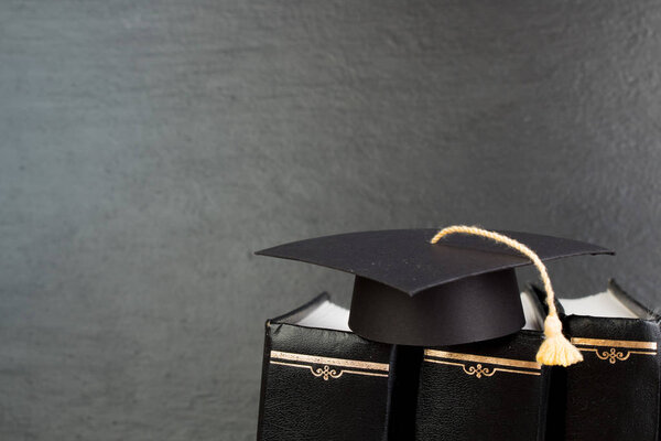 Концепция образования. Выпускная шляпа с золотой кисточкой на обложке. Концепция права - с копировальным пространством для текста объявления