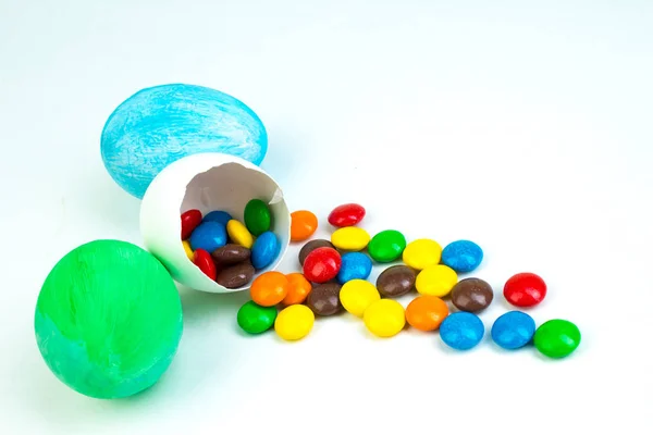 Happy Easter. Broken Easter egg with multi-colored candy decorations. on white background. Colorful eggs