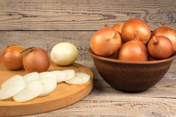 onion in a plate, onion rings on a cutting board. country style.