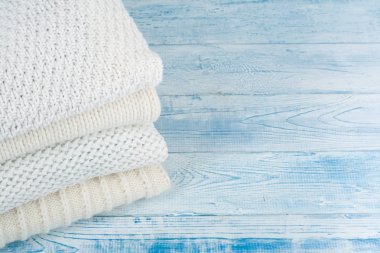 Örgü yün kazaklar. Mavi ahşap arka planda örülmüş kışlık giysiler, kazaklar, örgü giysiler, metin için yer