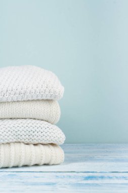 Örgü yün kazaklar. Ahşap arka planda örülmüş kış kıyafetleri, kazaklar, örgü giysileri, metin için yer.