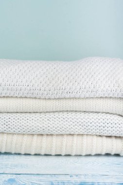 Örgü yün kazaklar. Ahşap arka planda örülmüş kış kıyafetleri, kazaklar, örgü giysileri, metin için yer.