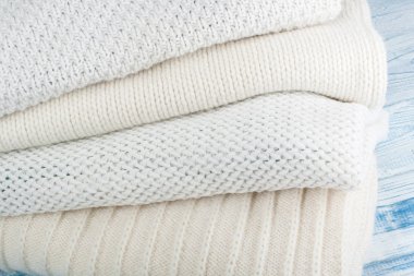 Örgü yün kazaklar. Ahşap arka planda örülmüş kış kıyafetleri, kazaklar, örgü giysileri, metin için yer.