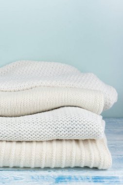 Örgü yün kazaklar. Ahşap arka planda örülmüş kış kıyafetleri, kazaklar, örgü giysileri, metin için yer.